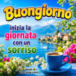 Buongiorno Smile Wish Image featuring a steaming blue coffee cup, colourful flowers, a peaceful lakeside view and mountains symbolising a cheerful start to the day.